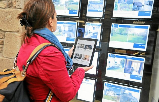 PHOTO dame devant une agence immobilière
