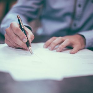 Un homme signant un contrat sur un bureau